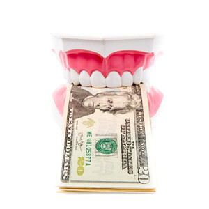 dentures holding money showing how implants can save you money