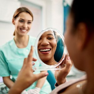 Patient smiling at reflection in treatment chair