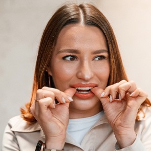 Patient putting on clear aligner in treatment room