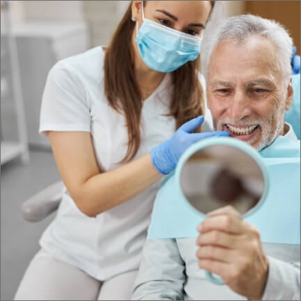 Man looking at smile after receiving all on four dental implants