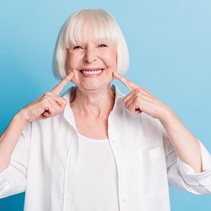 Woman pointing to her smile