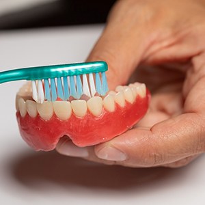 Man brushing his dentures