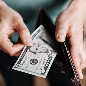 Man looking at cash in wallet