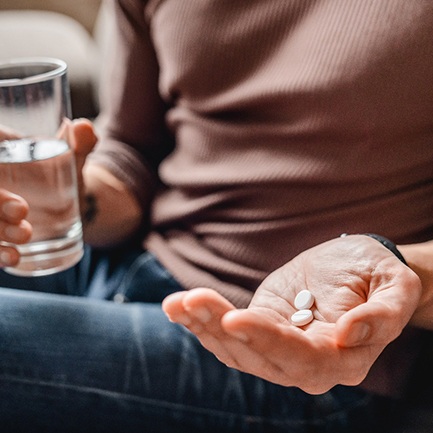 a person taking pain relievers after tooth extractions in Hackettstown