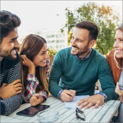 Group of friends smiling together and enjoying the benefits of dental implants