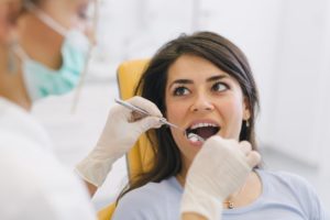 A woman gets her gums checked during an exam.