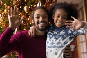 a parent and child smiling and waving 