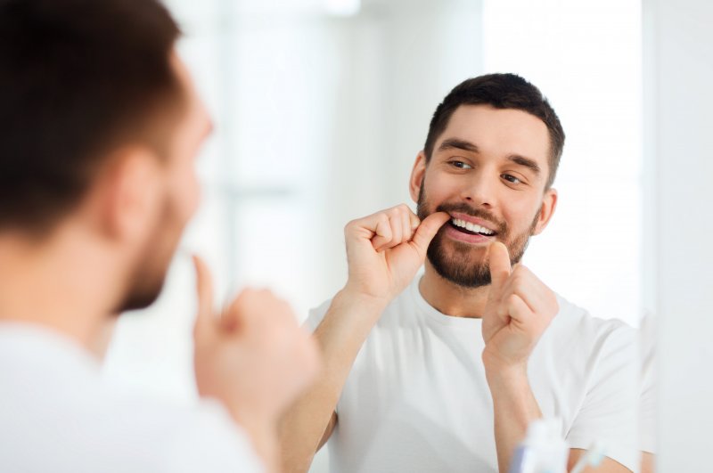 A man flossing dental implants