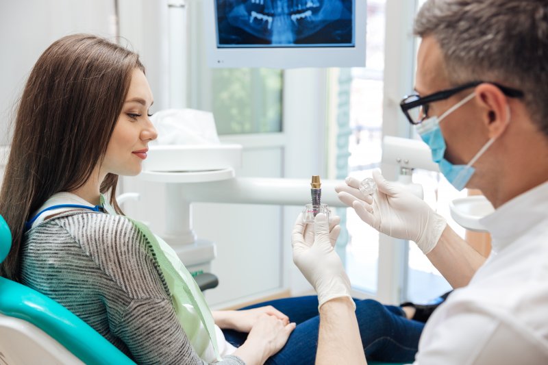 A dentist explaining dental implants with a concerned patient